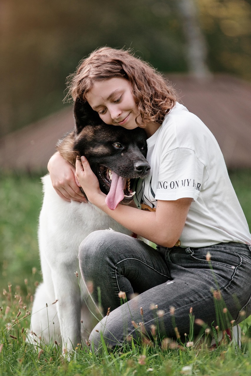 A person crouching to greet a dog, the dog leaning into them